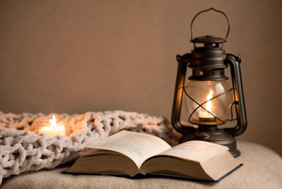 Open Book Beside Lit Lantern