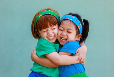 Two Asian girls hugging happily