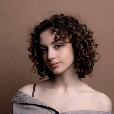 Woman with curly hair in off-shoulder top