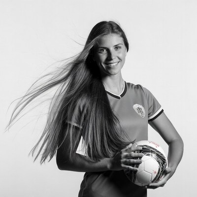 Woman in soccer jersey holding ball