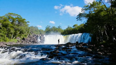 Man standing before majestic waterfall
