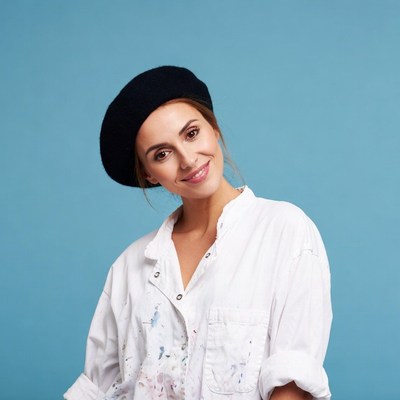 Woman wearing black beret and paint-splattered shirt