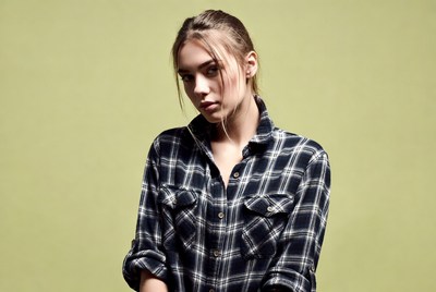Woman in plaid shirt on green background