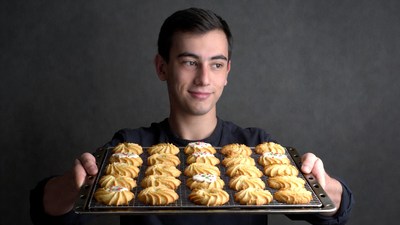 Young man holding tray of cookies