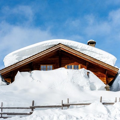 Snow-covered wooden chalet in mountains