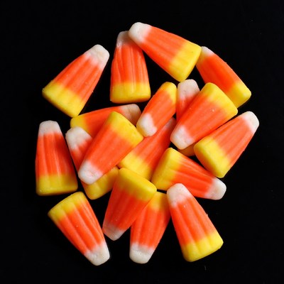 Candy corn pile on black background