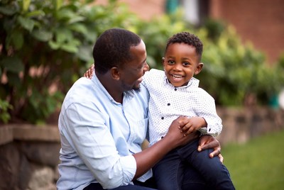 African father holding smiling son
