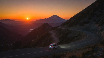 Car on mountain road at sunset