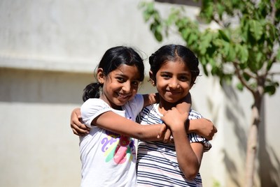 Two Indian girls hugging outdoors