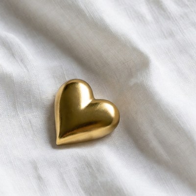 Gold heart on white fabric