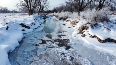 Frozen Creek in Snowy Landscape