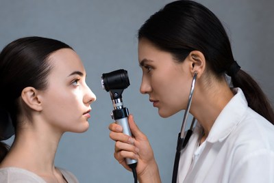 Asian doctor examining patient's eyes