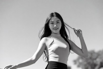 Asian woman twirling long hair outdoors