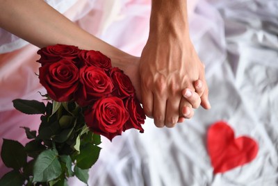 Couple holding red roses bouquet
