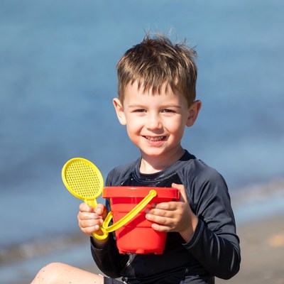 Boy holding beach bucket and shovel