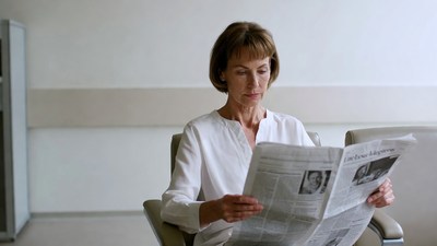 Woman reading newspaper in hospital