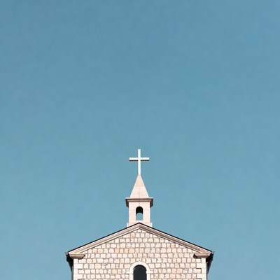 Stone Church with Cross on Blue Sky