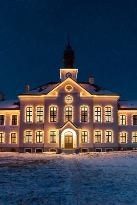 Lit Manor House in Snowy Night