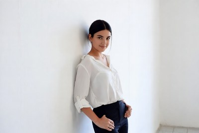 Woman leaning against white wall