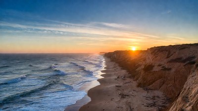 Sunset over ocean beach cliffs