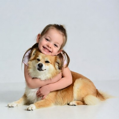 Girl hugging fluffy Pomeranian dog