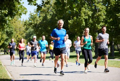 Group of runners jogging on tree-lined path