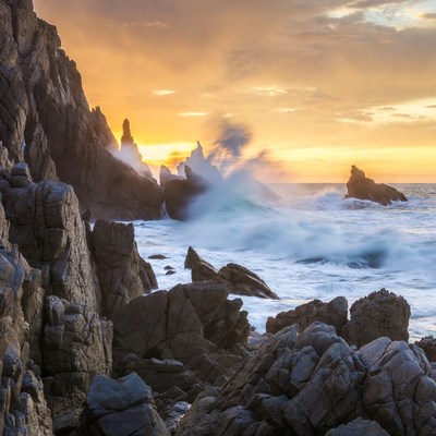 Ocean Waves Crashing on Rocks at Sunset