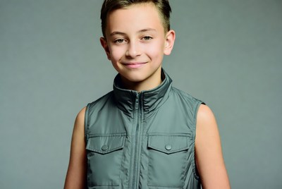 Young boy smiling in gray vest