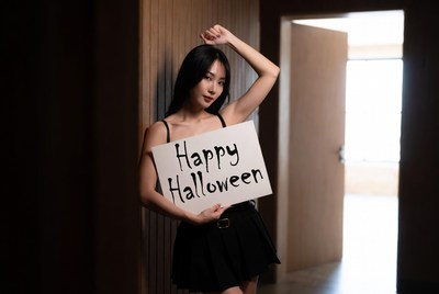 Asian woman holding Happy Halloween sign