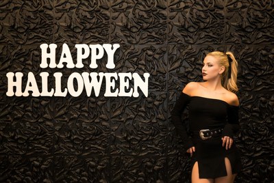 Blonde woman with Happy Halloween sign