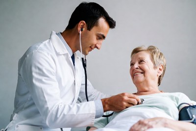 Doctor checking elderly woman's heart