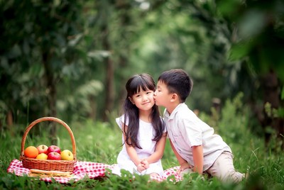 Asian boy kissing girl with apples