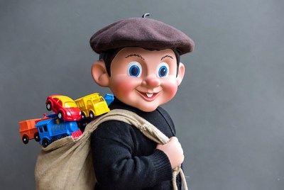 Vintage boy doll with toy cars in sack