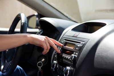 Woman hand adjusting car stereo