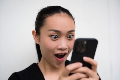 Asian woman surprised by phone