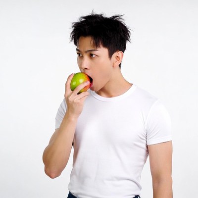 Asian man biting green apple