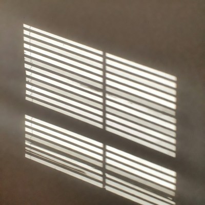 Blinds casting shadows on wall