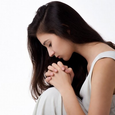 Asian woman praying with clasped hands