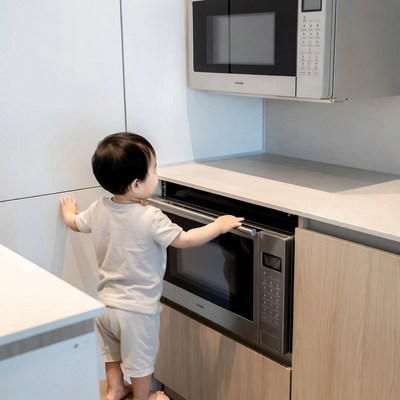 Asian toddler reaching for microwave