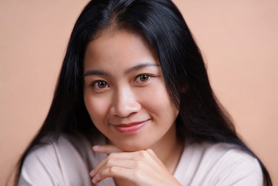 Asian woman smiling with hand on chin