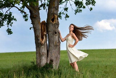 Woman leaning on tree in field
