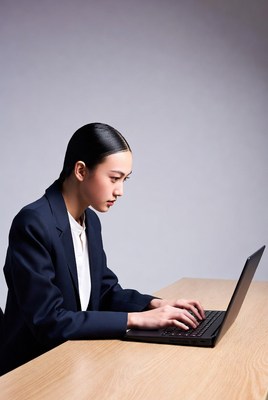 Asian woman typing on laptop