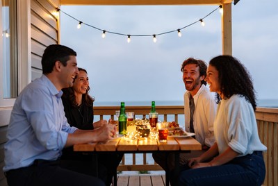 Four friends laughing at patio table
