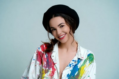 Woman in black beret and paint-splattered shirt