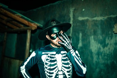 Man in skeleton costume with skull mask