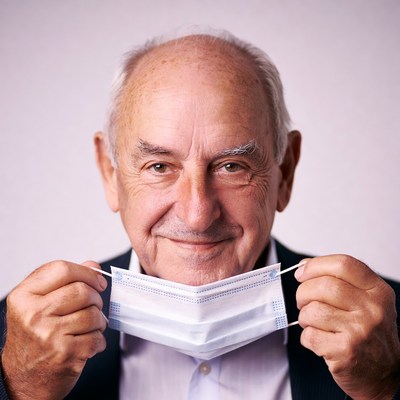 Elderly man holding face mask