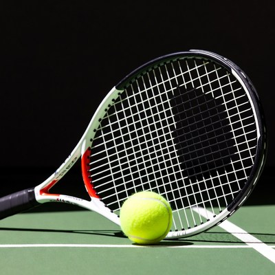 Tennis racket and ball on court