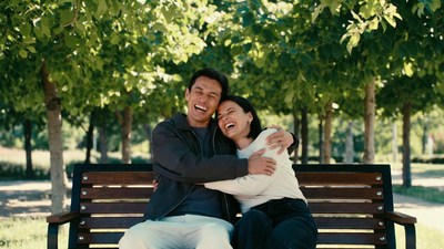 Asian couple hugging on park bench