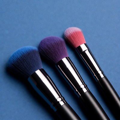 Colorful Makeup Brushes on Blue Background