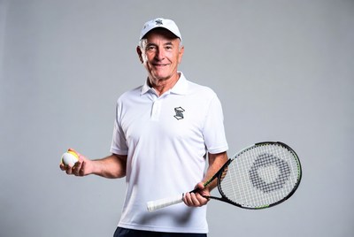 Senior man holding tennis racket and ball